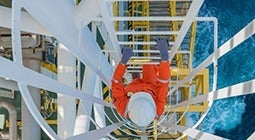 aerial shot of a person climbing down an oil rig