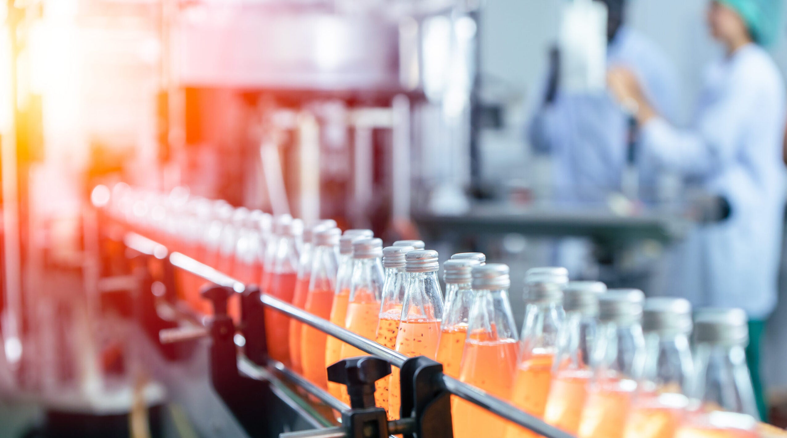 Drink factory production line fruit juice beverage product at conveyor belt.