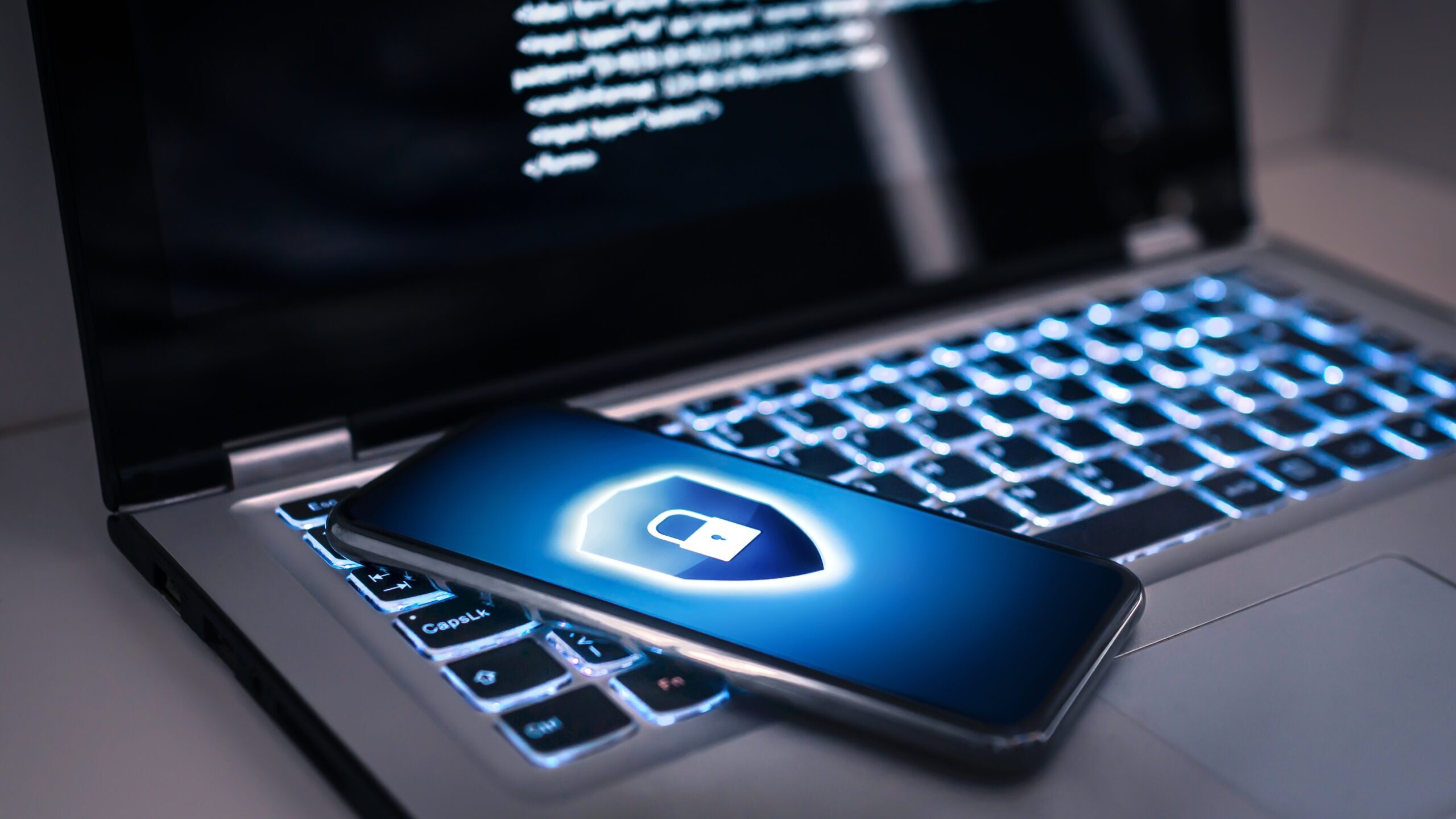Phone lock to protect from cyber scam, online data fraud or identity theft. Laptop with hacker virus code in screen. Phishing, cybersecurity danger or ransomware attack. Encrypted privacy in email.