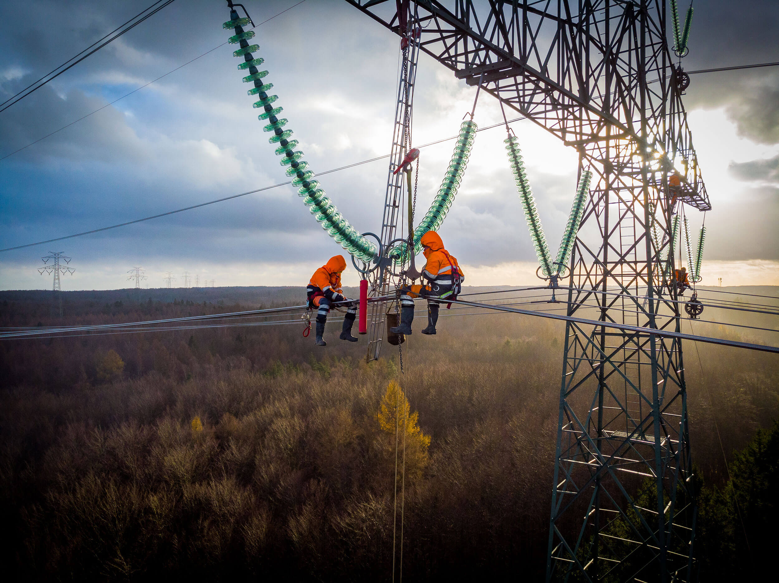 POMERANIA DISTRICT,POLAND - DECEMBER 8,2018: Aerial view of electricians working on electric poles to install and repair power lines.